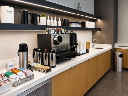 a coffee shop with a coffee maker on a counter at AC Hotel by Marriott Orlando Downtown in Orlando