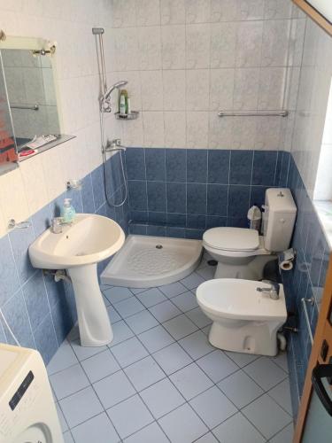 a blue and white bathroom with a toilet and a sink at Nomad Villa Tirana in Tirana