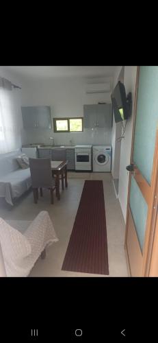 a kitchen with a table and a dining room at Vila Ameli Bucimas in Buçimas