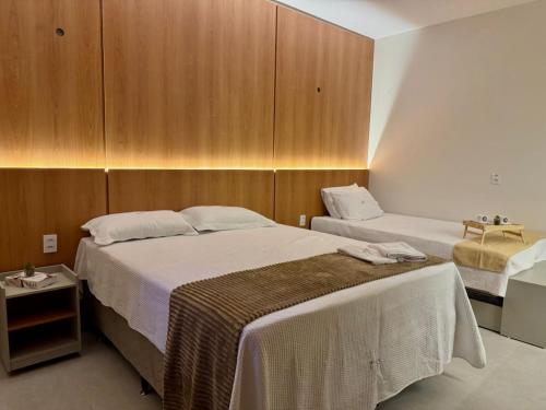 a hotel room with two beds and wooden cabinets at Residencial Ibiapaba Flat 16 - Com piscina e ótima localização in Camocim