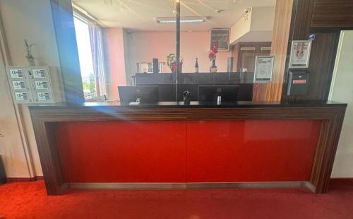 a counter in a room with a red door at DORMERO Express Hotel Passau in Passau