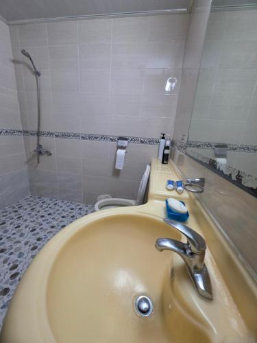 a bathroom with a sink and a tub with a mirror at Happy Hotel in Jeju