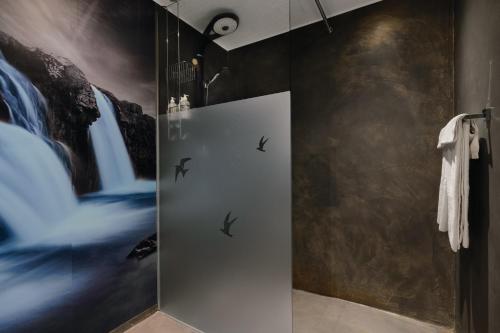a bathroom with a shower with birds on the wall at Hotel Kriunes in Reykjavík