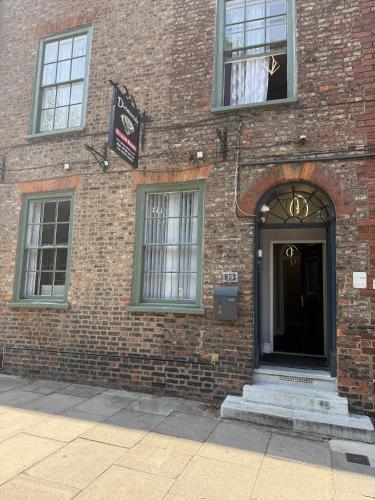 a brick building with a door and a sign on it at Diamonds Inn Ltd in York