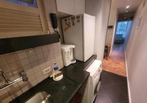 a small kitchen with a sink and a refrigerator at SUH Leme 04 Studio Comfort in Rio de Janeiro