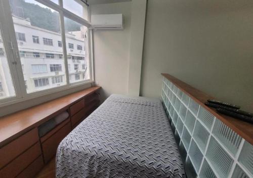 a room with a bed and a window with a bench at SUH Leme 04 Studio Comfort in Rio de Janeiro