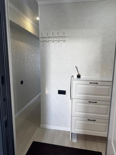 a dressing room with a white dresser and a mirror at Квартира 2 комнаты in Balqash