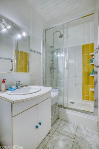 a white bathroom with a shower and a sink at Le Saint Roch in Villeréal