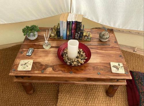 a table with a candle and a bowl of rocks on it at Camping at the Barge in Alton Barnes