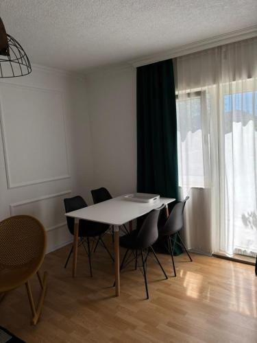 a dining room with a table and chairs and a window at Apartmani Daria in Ljubuški