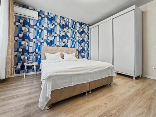 a bedroom with a bed and a blue and white wall at Konstanzer 44 - Urban Studio - Iulius Mall - AC in Iaşi