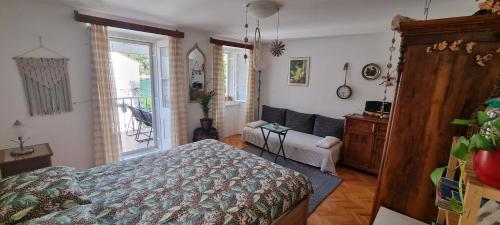 a bedroom with a bed and a couch at Sea La Vie in Valun