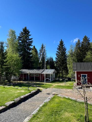 a red house with a garage and a yard at Guest cabin, Haukipudas, sauna and free parking in Haukipudas