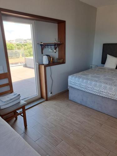 a bedroom with a bed and a sliding glass door at Caravela in Perafita