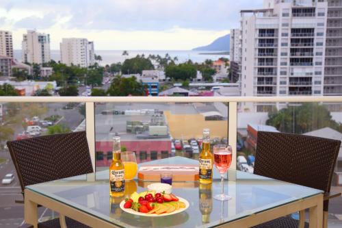 a table with drinks and a plate of fruit on a balcony at Cairns Central Plaza Apartment Hotel Official in Cairns