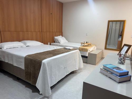 a hotel room with two beds and a mirror at Residencial Ibiapaba FLAT 31 - com piscina e ótima localização in Camocim