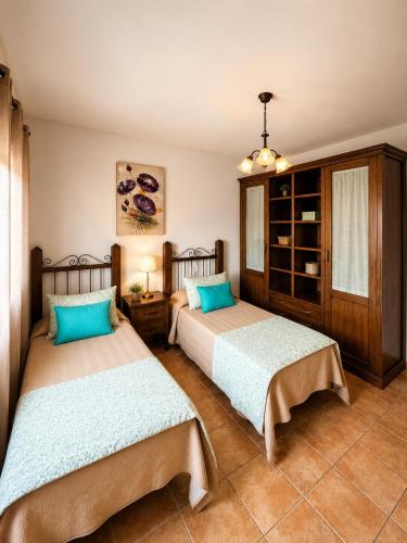 two beds sitting in a room with at Villa El Valle - Piscina climatizada in Tarajalejo