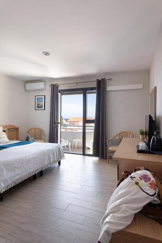 a bedroom with a bed and a view of the ocean at Hôtel Maristella in Algajola