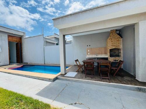 a backyard with a table and a swimming pool at Casa Perfeita Paracuru in Paracuru