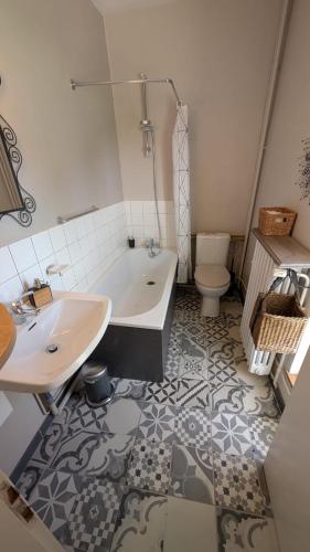 a bathroom with a tub and a sink and a toilet at Manoir du Taillis in Heugon