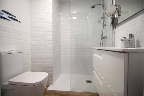 a white bathroom with a toilet and a sink at Santa Ana 22 by homeprive in El Verger