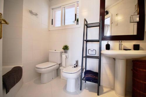 a bathroom with a toilet and a sink and a mirror at Golden Paradise 75 by homeprive in Jávea