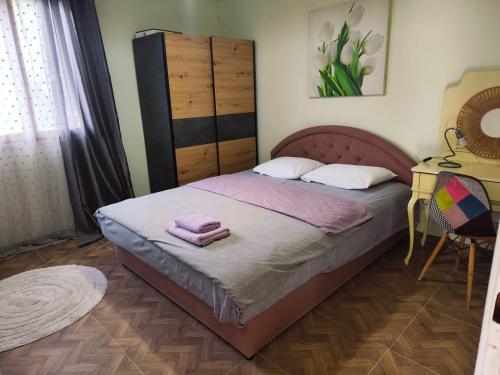 a bedroom with a bed with two towels on it at Jela - Spacious Two-Bedroom Apartment near City Center with Free Parking & Wi-Fi in Podgorica