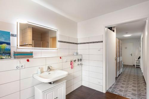 a white bathroom with a sink and a mirror at Ferienwohnung Seeglück in Lauchhammer