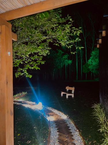 a park with two benches under a canopy at Cabana de teto de vidro in Santa Cruz do Sul