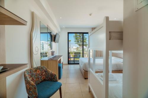 a bedroom with a bed and a desk and a chair at Stamatia Hotel in Ayia Napa