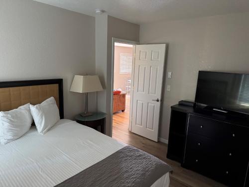 a bedroom with a bed and a flat screen tv at The Lake Huron Resort in Oscoda