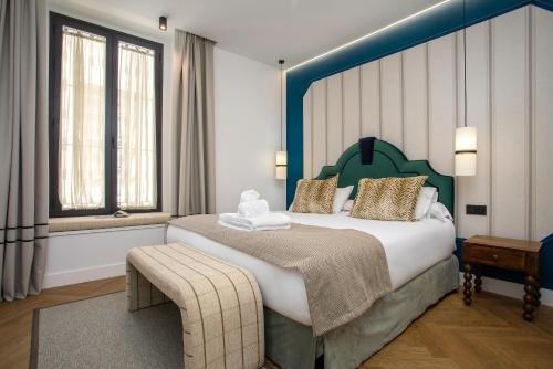 a bedroom with a large bed with a blue headboard at CSE MS Museo Select in Seville