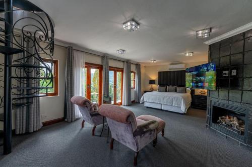 a large bedroom with a bed and a fireplace at IL Castello Boutique Hotel in Clarens