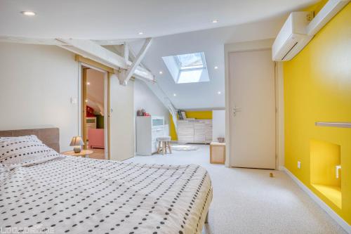 a bedroom with a bed and a yellow wall at Maison Françoise in Monpazier