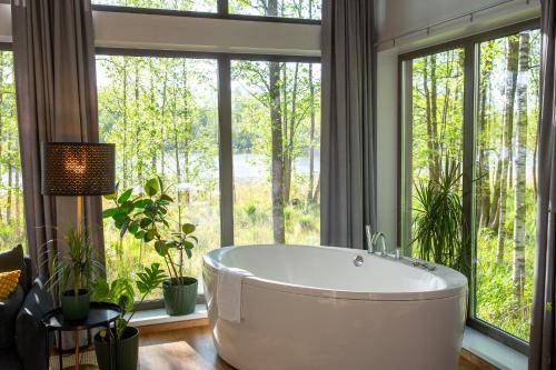 a bathroom with a large tub in front of a window at Brīvdienu māja Empagi in Lādezers
