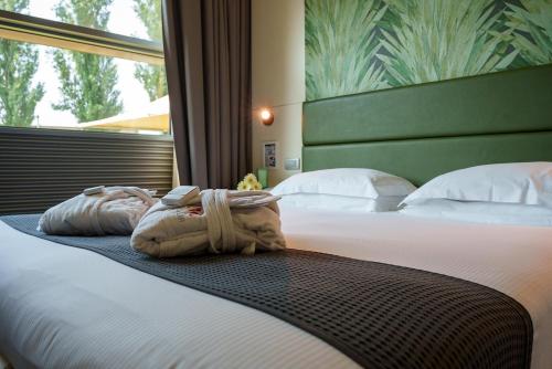 a hotel room with a bed with two towels on it at Best Western Hotel Green City in Parma