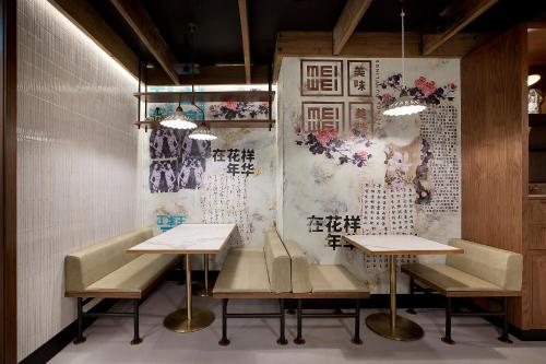 a restaurant with two tables and chairs in front of a wall at The Star Grand at The Star Gold Coast in Gold Coast