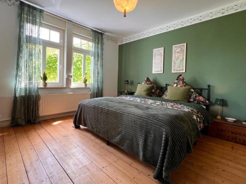 a bedroom with green walls and a bed in it at Villa Belle in Freudenberg