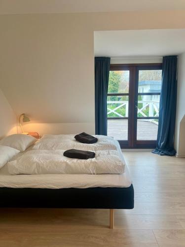 a bed with two black towels on it in a bedroom at Cozy house with garden in Odense
