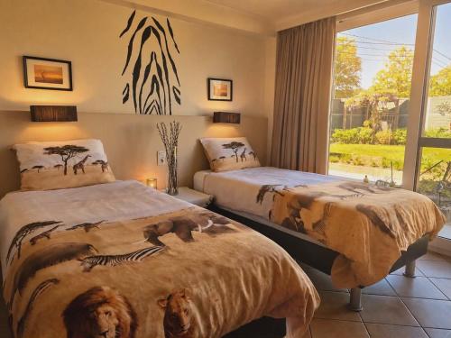a bedroom with two beds and a window at B&B The Protea in Zonnebeke