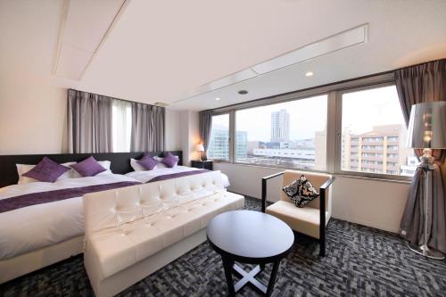 um quarto de hotel com uma cama grande e uma janela grande em Centurion Hotel Villa Suite Fukui Ekimae em Fukui