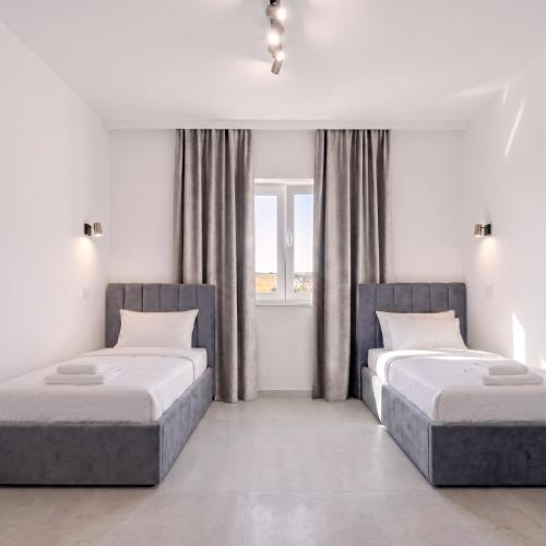 a bedroom with two beds and a window at Express Apartments Suceava in Ipoteşti