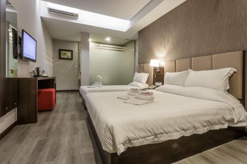 a hotel room with a large bed and a television at Hotel Trillium in Kuala Lumpur