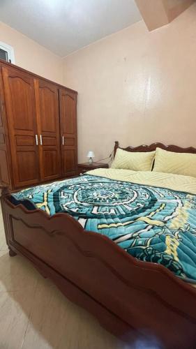 a bedroom with a large bed with a blue and white blanket at MRIRT Home N4 in Jemaa de Mrirt