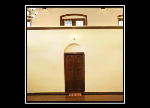a door in a white wall with shelves at Pattiah Naidu Palace in Palani