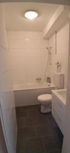 a bathroom with a tub and a toilet and a sink at A&H Apartment in Oberhausen