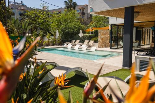 a swimming pool in a yard with some flowers at Instants Boutique Hotel in Cambrils