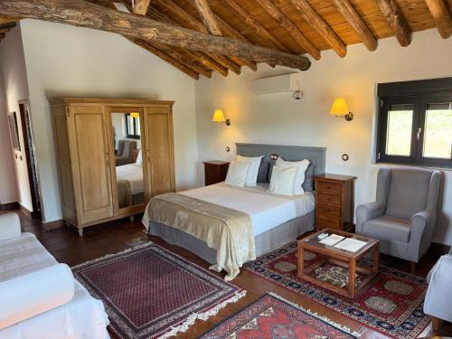 a bedroom with a bed and a couch and a chair at La Guzmana de Ronda in Ronda