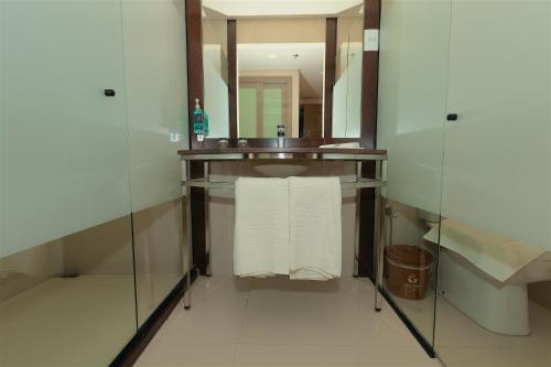 a bathroom with a sink and a mirror and towels at Vila Galé Paulista in São Paulo