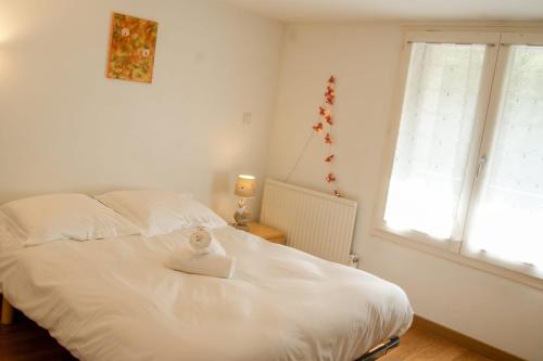 a bedroom with a white bed and a window at Feet in the water! in Duingt